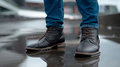 Leather shoes worn by person in denim pants