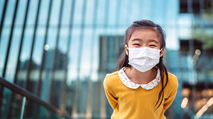 Young girl smiling while wearing a facemask