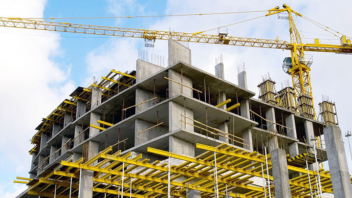 Large office building under construction with scaffolding and a crane