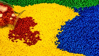 Beads of red, blue, yellow, and green polymer beads