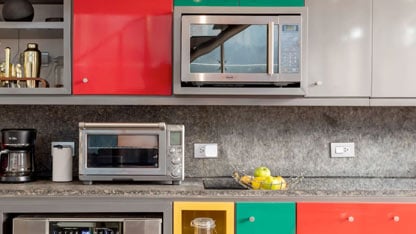 A modern kitchen in red and green with various appliances