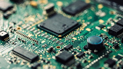 Close-up view of a green printed circuit board (PCB) with various electronic components