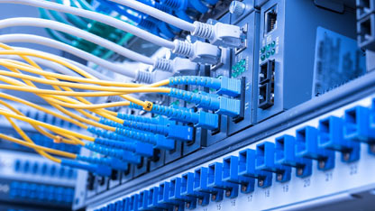 A network server with multiple connected cables, including yellow and blue fiber optic lines