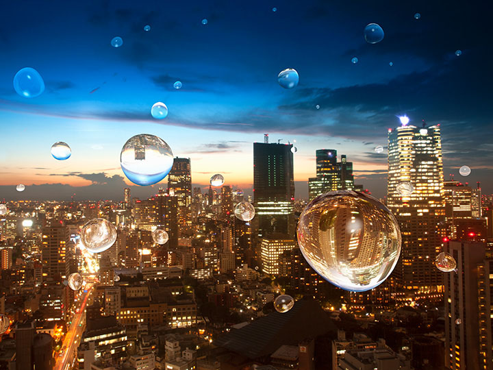 Water droplets on a window showing a city at dusk