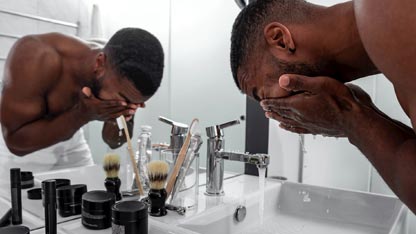 Man washing face at sink