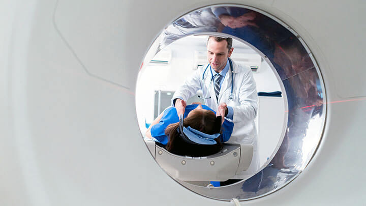 Doctor assisting patient at MRI machine