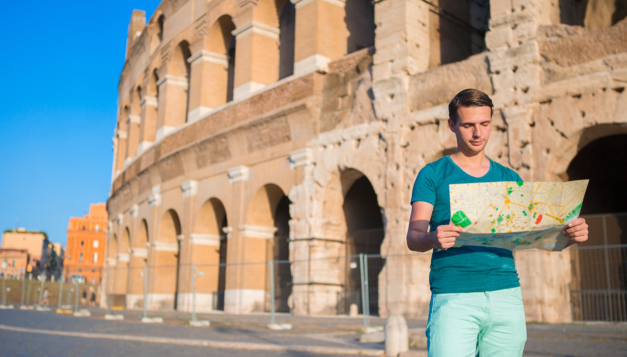 Man looking at map in front of ancient stadium