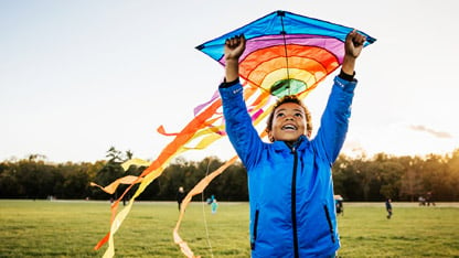 Young Boy Enjoying Learning How To Fly Kite