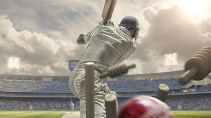 Rear view Of cricket ball hitting stumps behind batsman