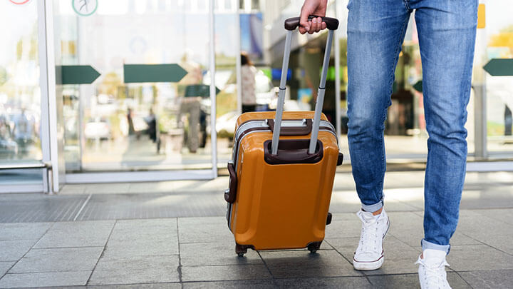 Rolling suitcase being pulled by man