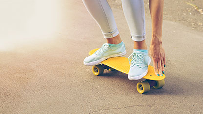 Person riding yellow skateboard